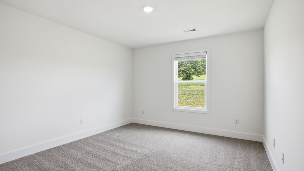 Primary bedroom with plush carpet floors and double light allowing windows