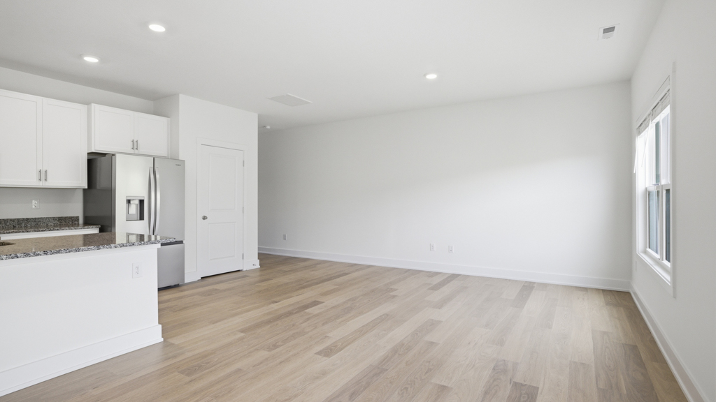 Spacious living and great  room space with light allowing windows