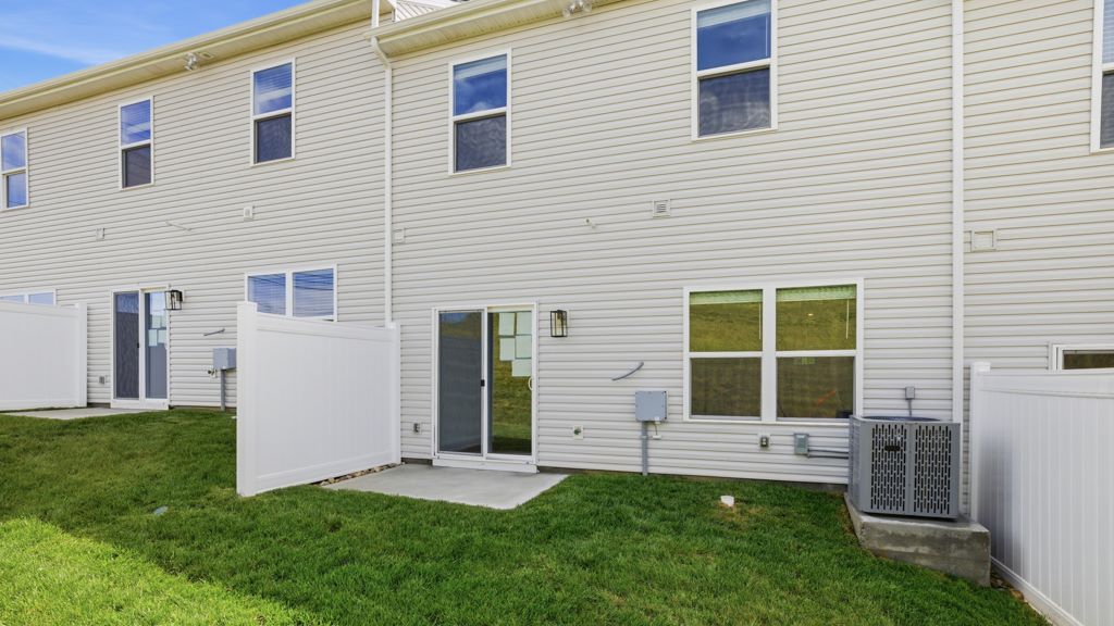 Rear exterior of home and landscaped sodded yard