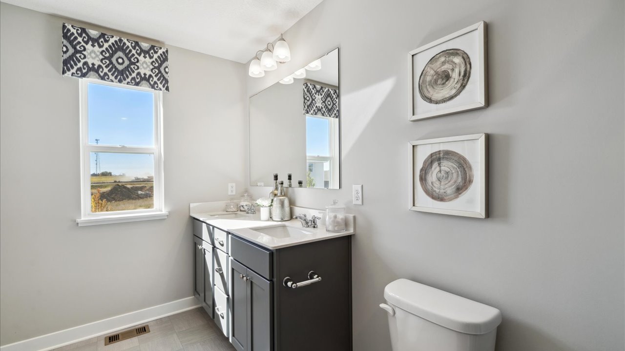 Private bathroom with harbor gray cabinets and quartz double vanity.