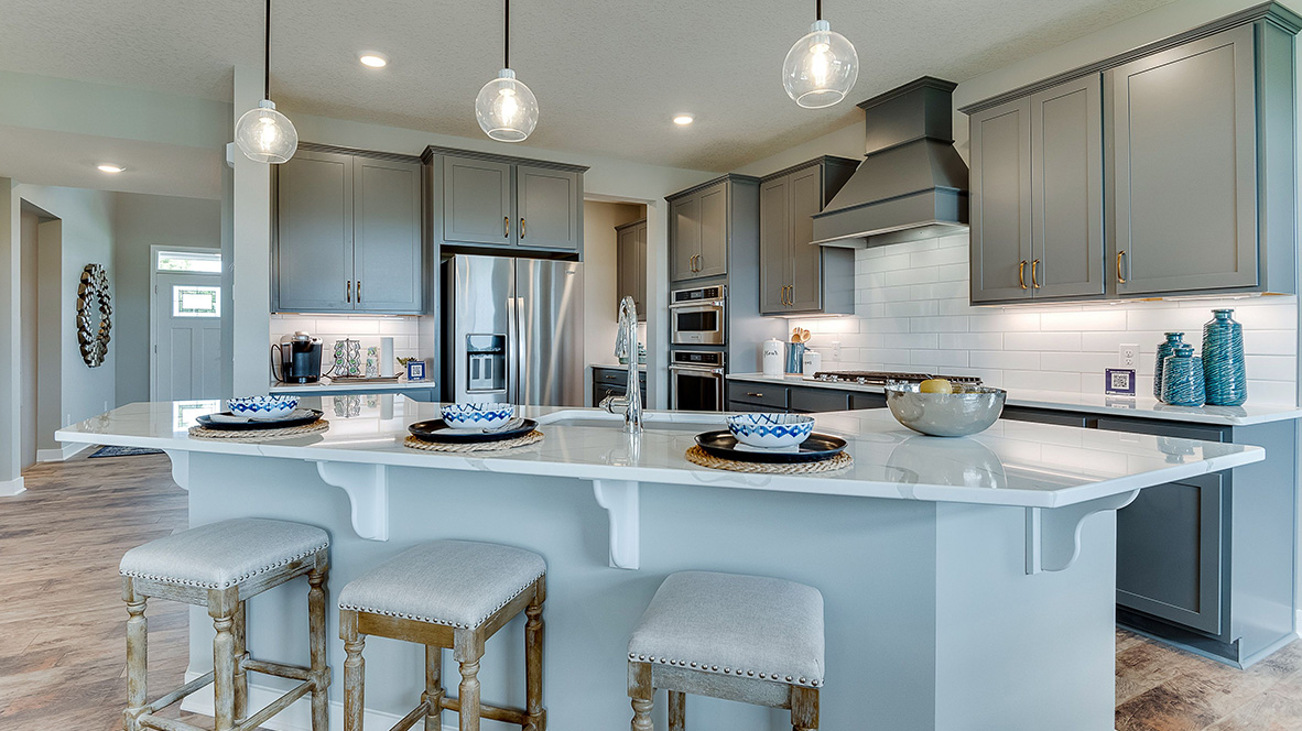 Kitchen with pendant lighting and angled island seating three.