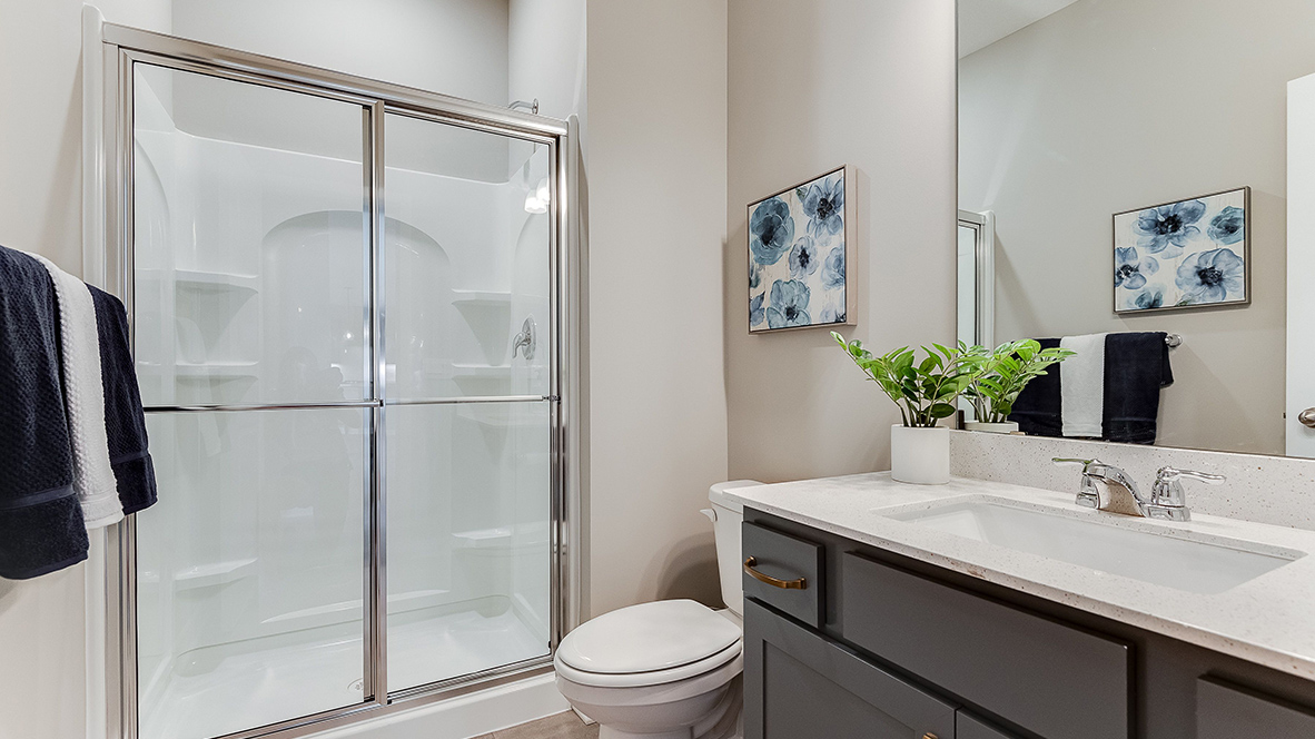 Main level bathroom with harbor gray cabinets and quartz vanity countertop.