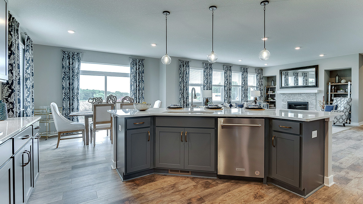 Kitchen island with stainless steel appliances and pendant lighting.