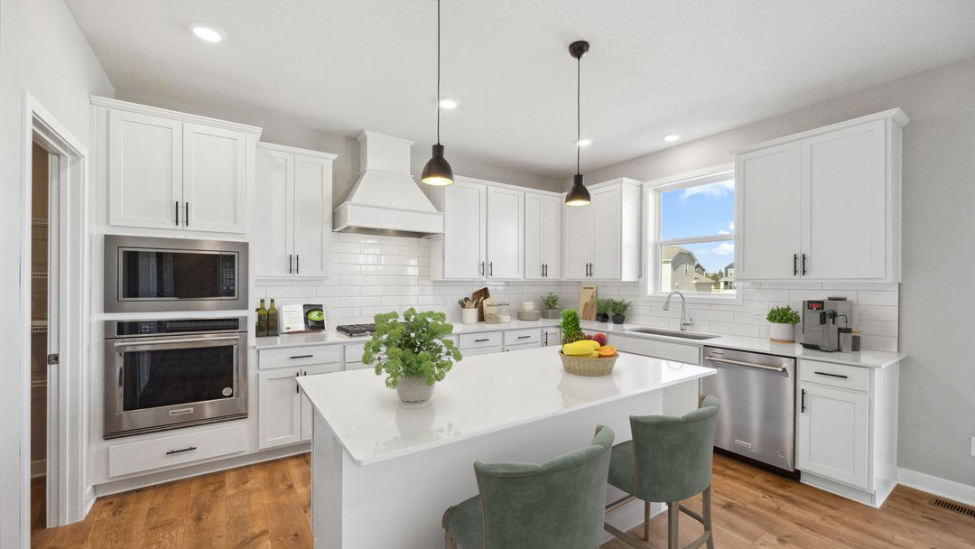 another view kitchen with white cabinetry, large island, and stainless steel appliances