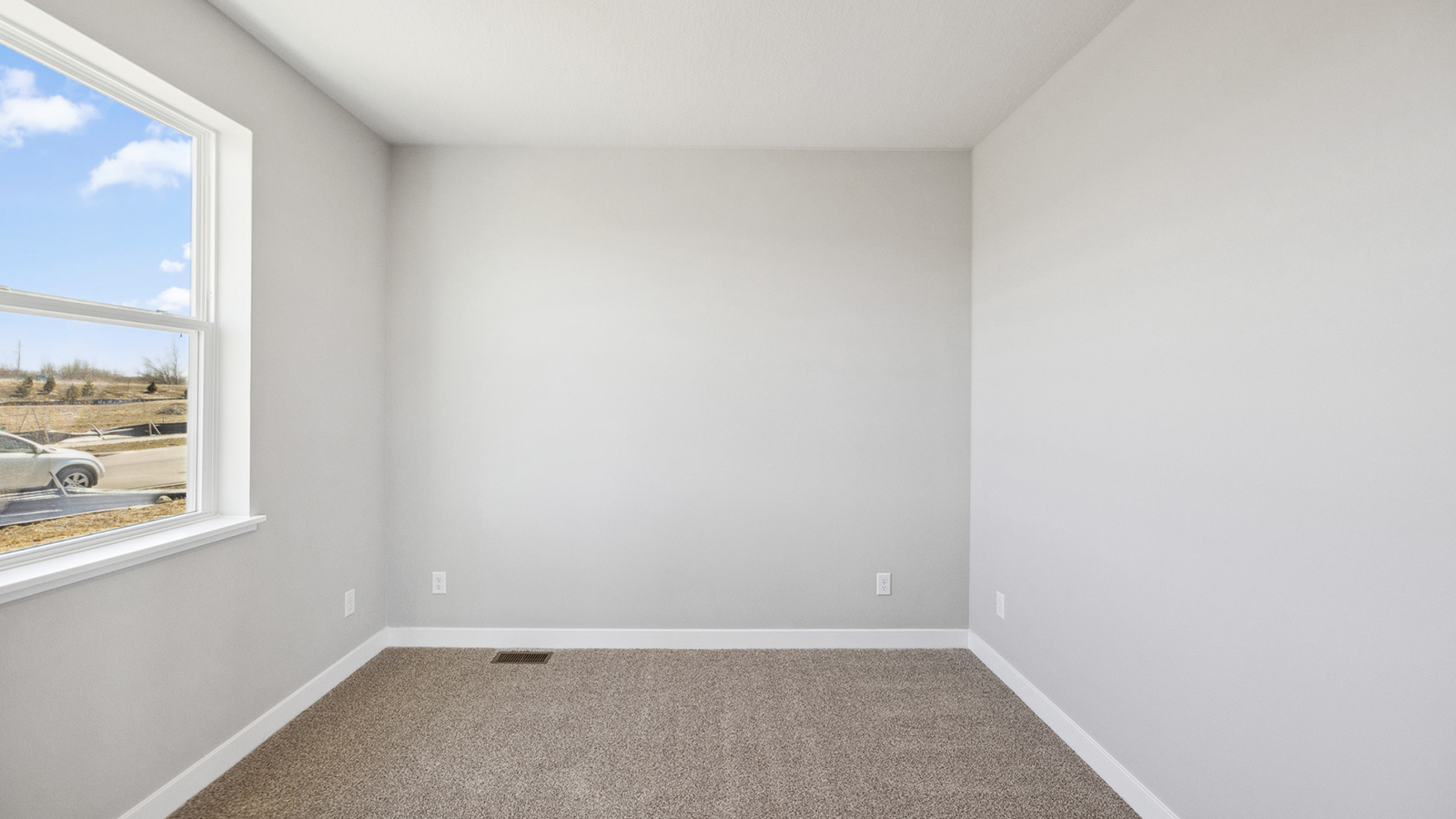 unfurnished bedroom with beige carpet, white walls and a window