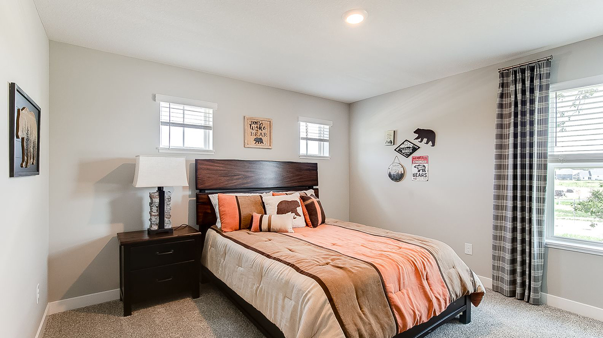 Carpeted secondary bedroom with walk-in closet.