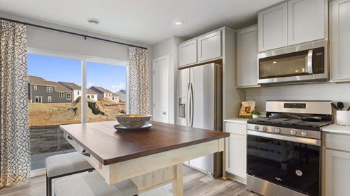 Open kitchen with stainless appliances and quartz countertops.