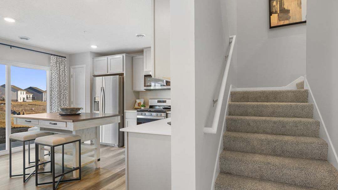View of kitchen area and carpeted staircase.
