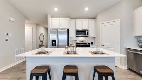 The kitcen has tiled backsplash, quartz countertops and stainless appliances.