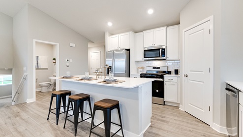 Angled view of kitchen and main level half bathroom.