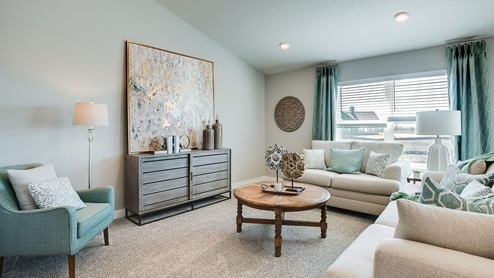 Carpeted living room on open concept main level.
