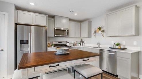 The kitchen features stainless appliances and quartz countertops.
