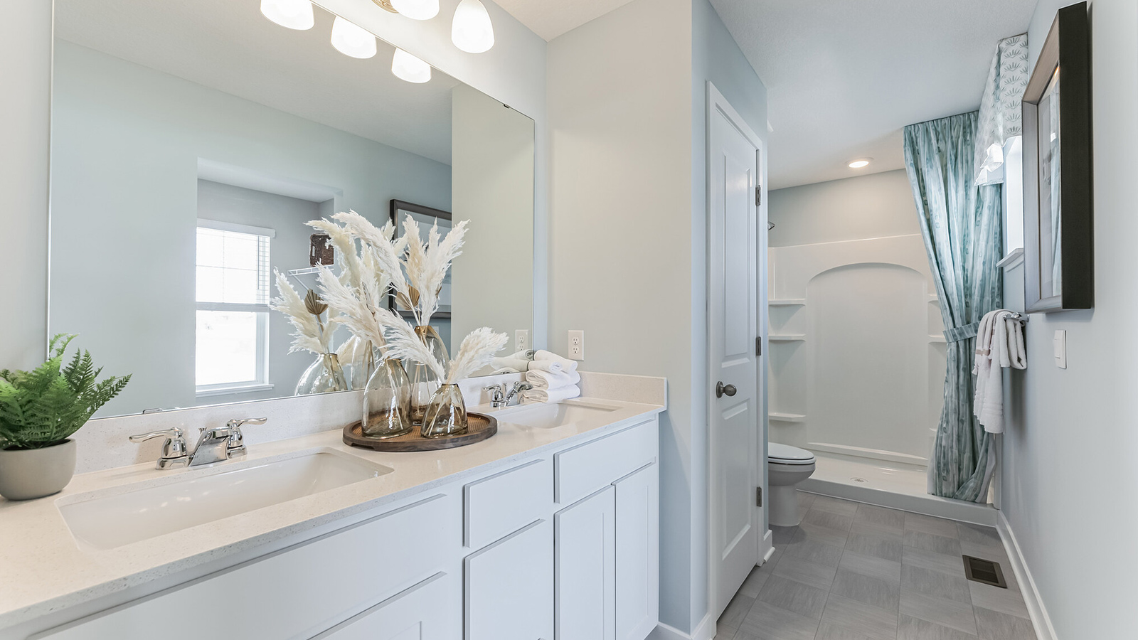 Private bathroom with white double sink vanity and quartz countertop.