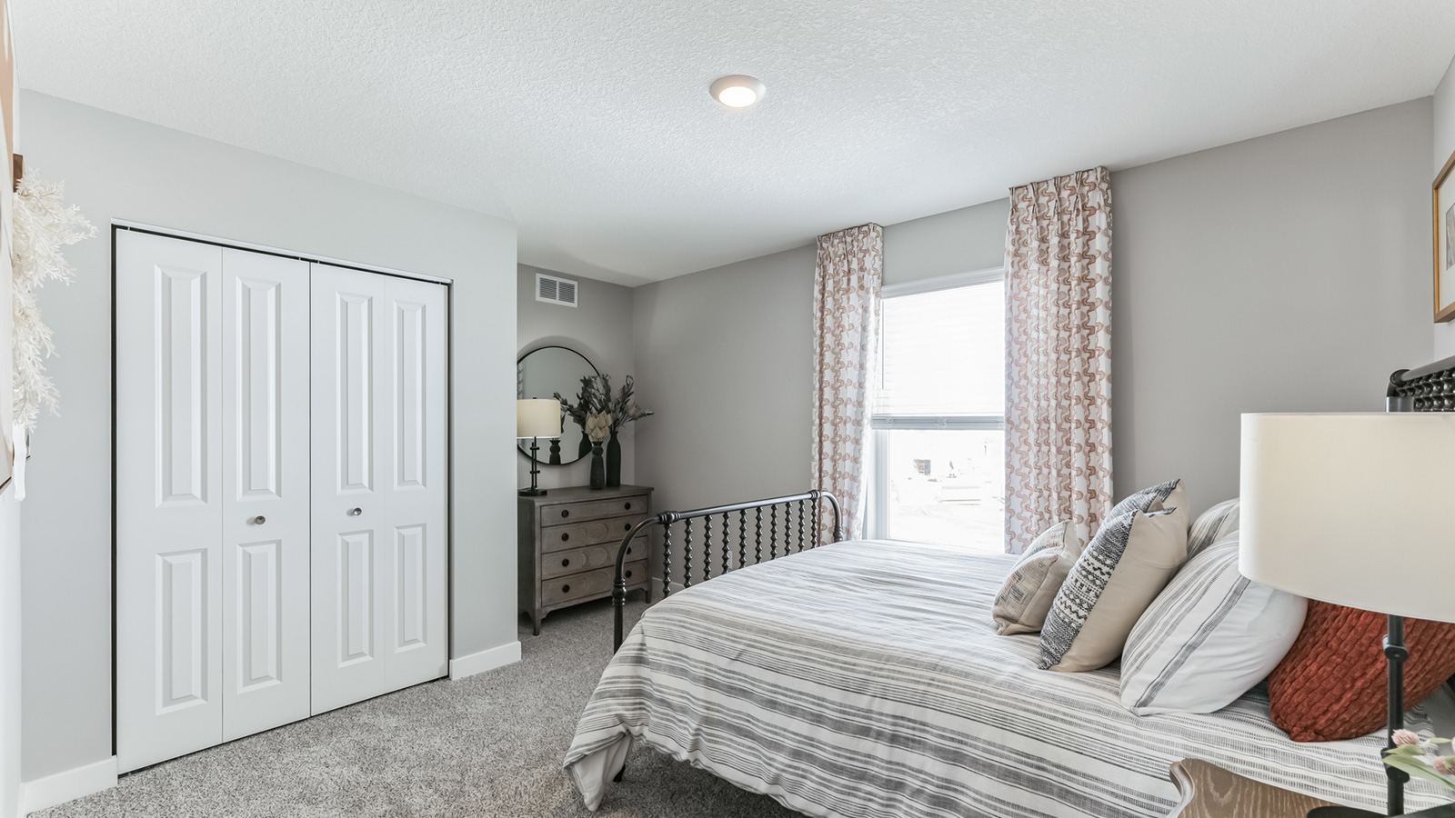 Carpeted secondary bedroom with standard closet.