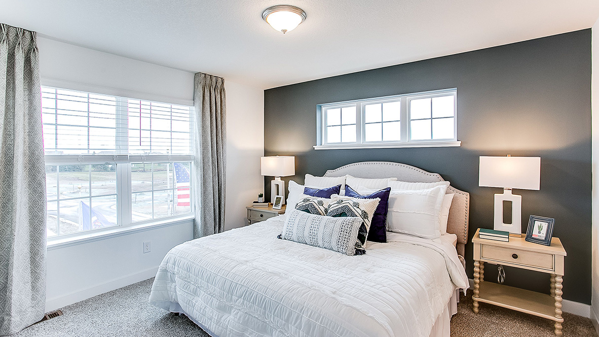 Carpeted bedroom suite with private bathroom and walk-in closet.