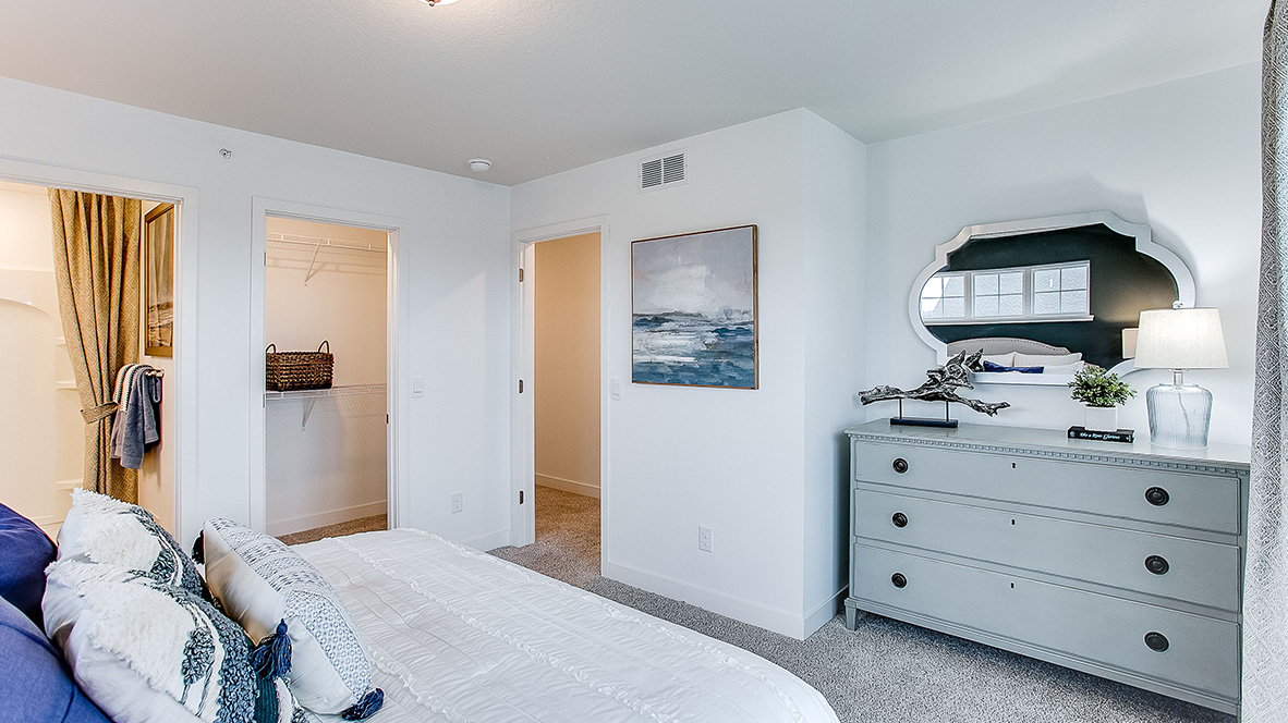 Carpeted bedroom suite with private bathroom and walk-in closet.