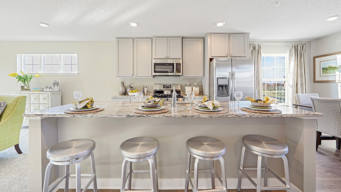 Straight on view of kitchen with gray cabinets and stainless steel appliances.