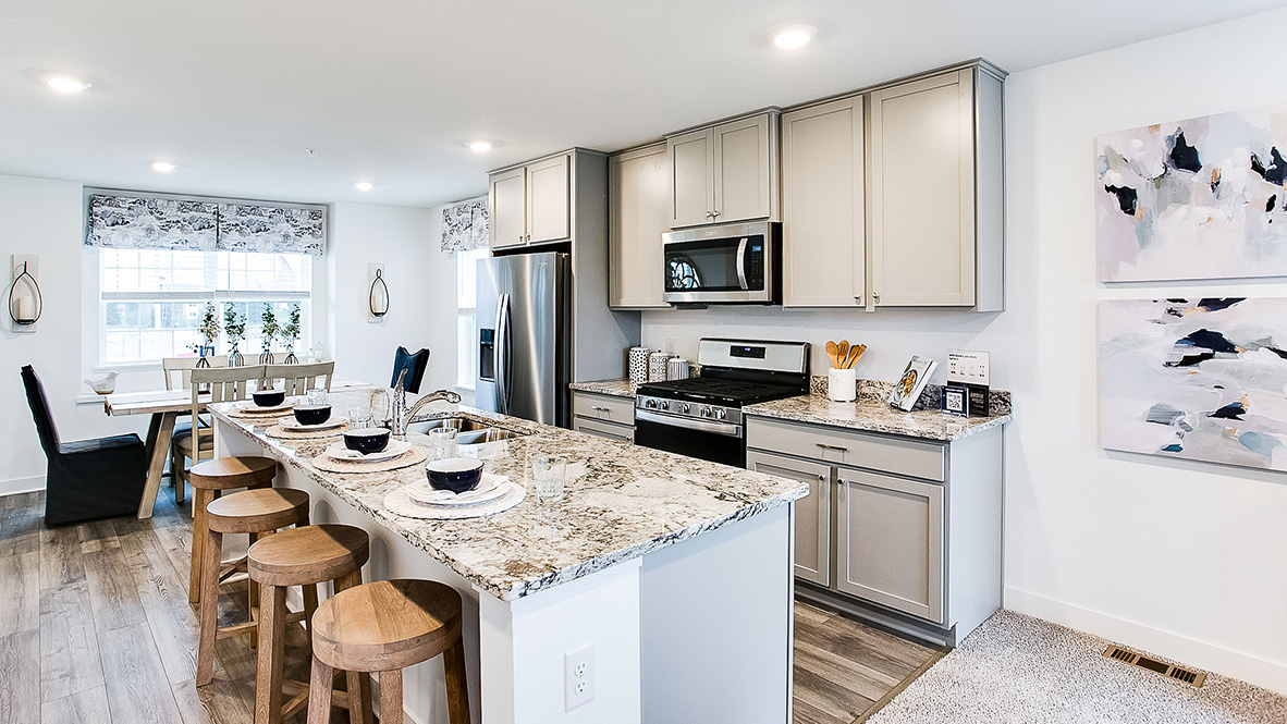 View of kitchen island and dinette areas on open concept main level.