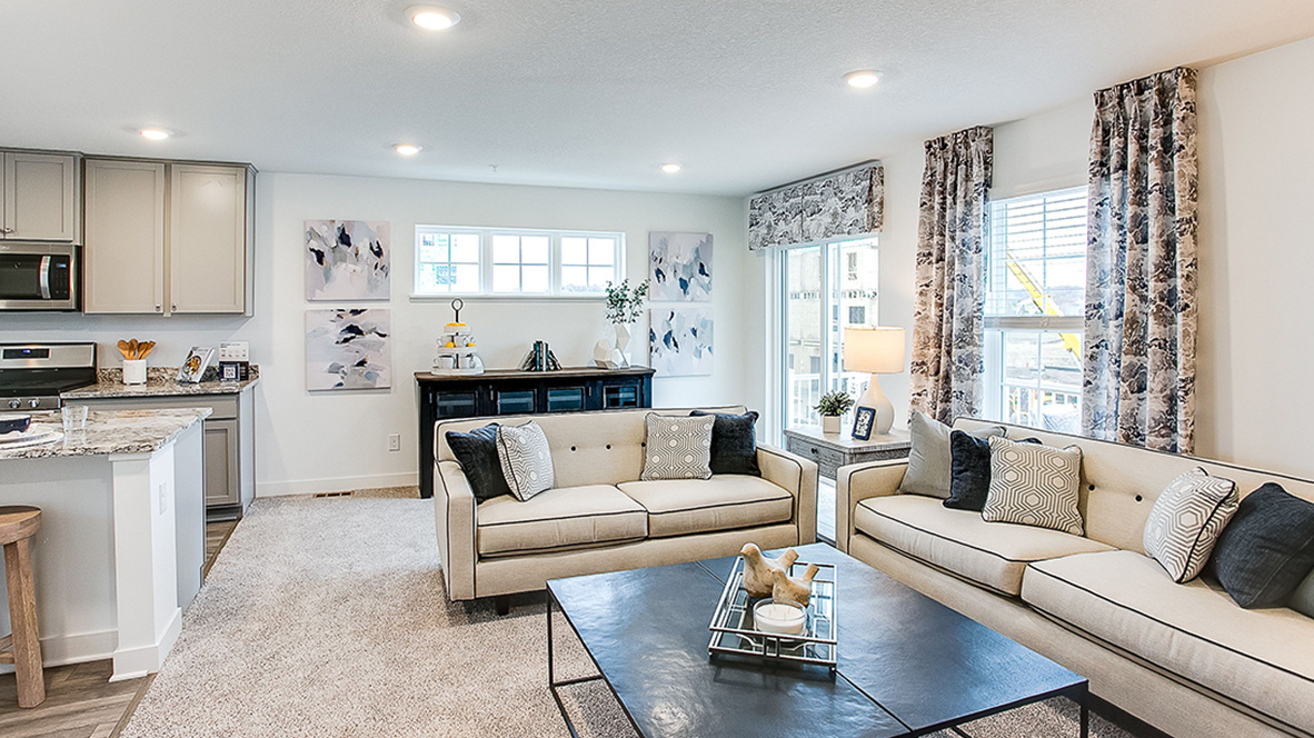 Carpeted living room with electric fireplace.