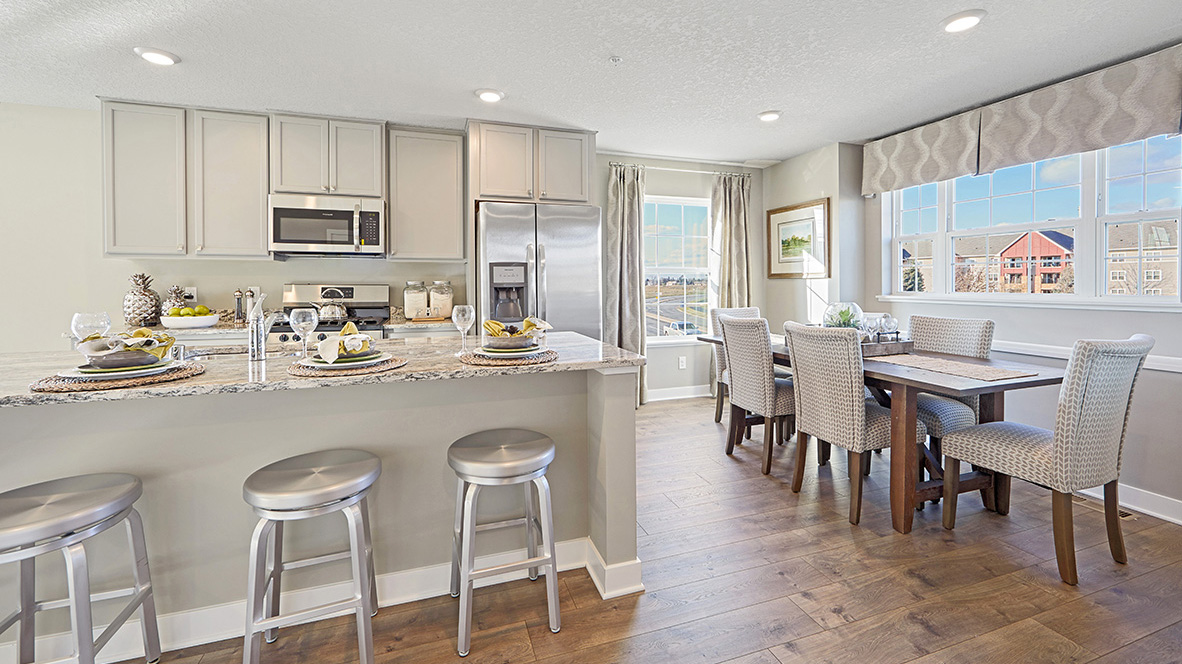 Kitchen with willow gray cabinets and quartz countertops.