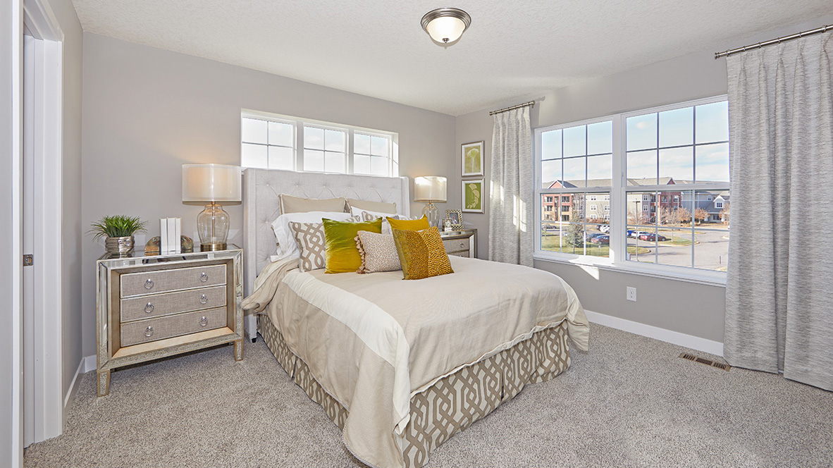 Carpeted bedroom suite with walk-in closet and private bathroom.