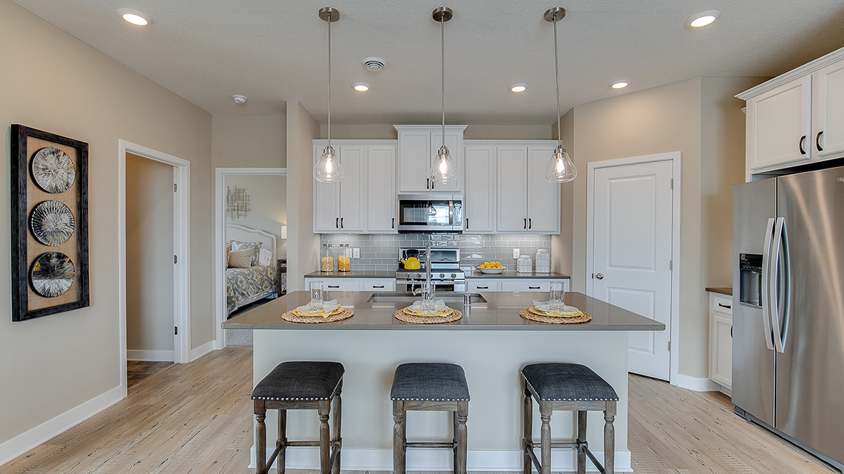 Straight on view of kitchen island with white siding and granite countertops.
