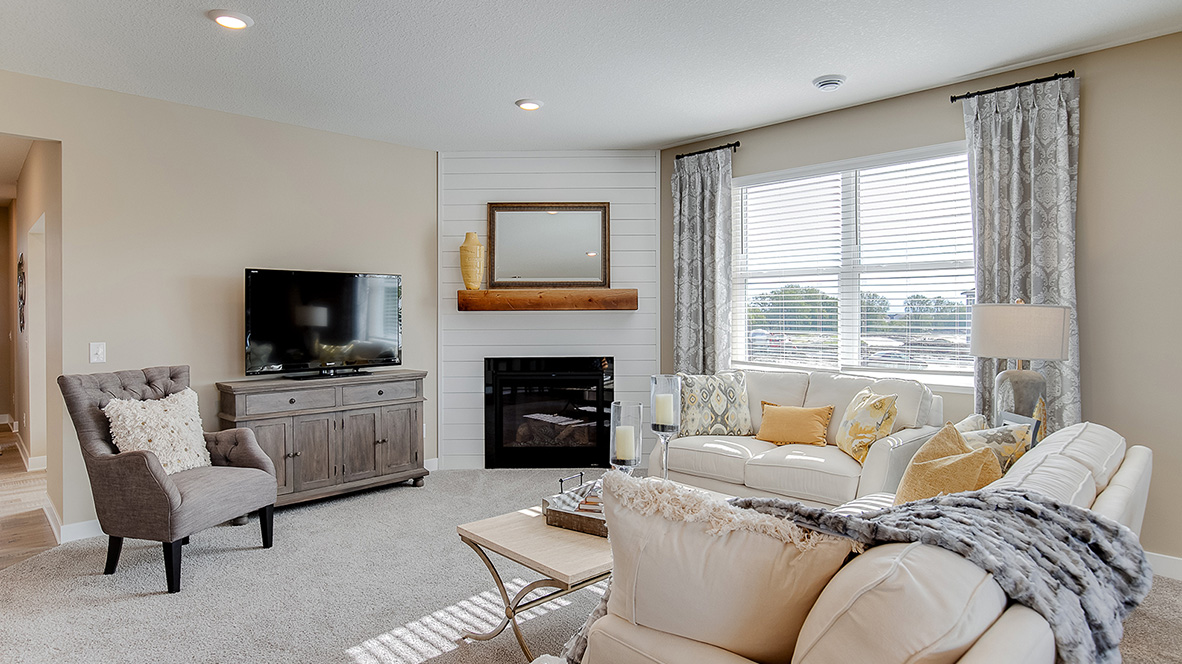 Carpeted living room with gas fireplace.