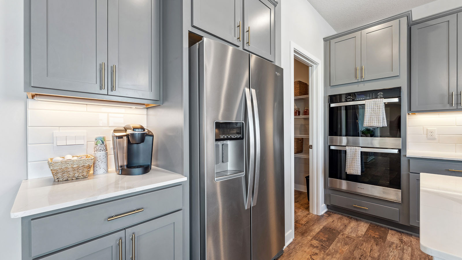 View of stainless steel Whirlpool fridge and double wall oven in kitchen area