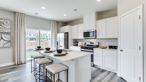 Angled view of kitchen and sliding glass doors leading out to patio.