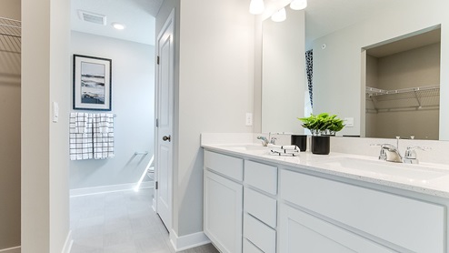 Private bathroom with white cabinetry and quartz double vanity.