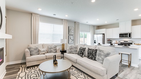 Open concept main level with living room and kitchen areas.