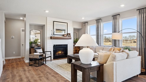 Living room area with gas fireplace and laminate wood flooring.