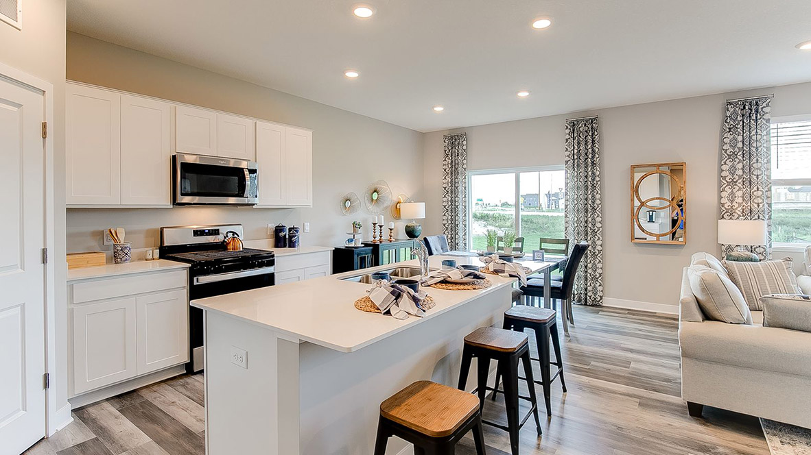 Kitchen peninsula with white cabinets and stainless steel appliances.