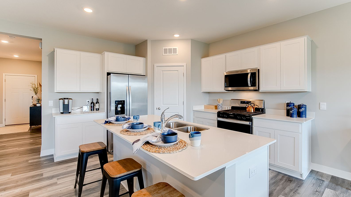 Kitchen peninsula with white cabinets and stainless steel appliances.