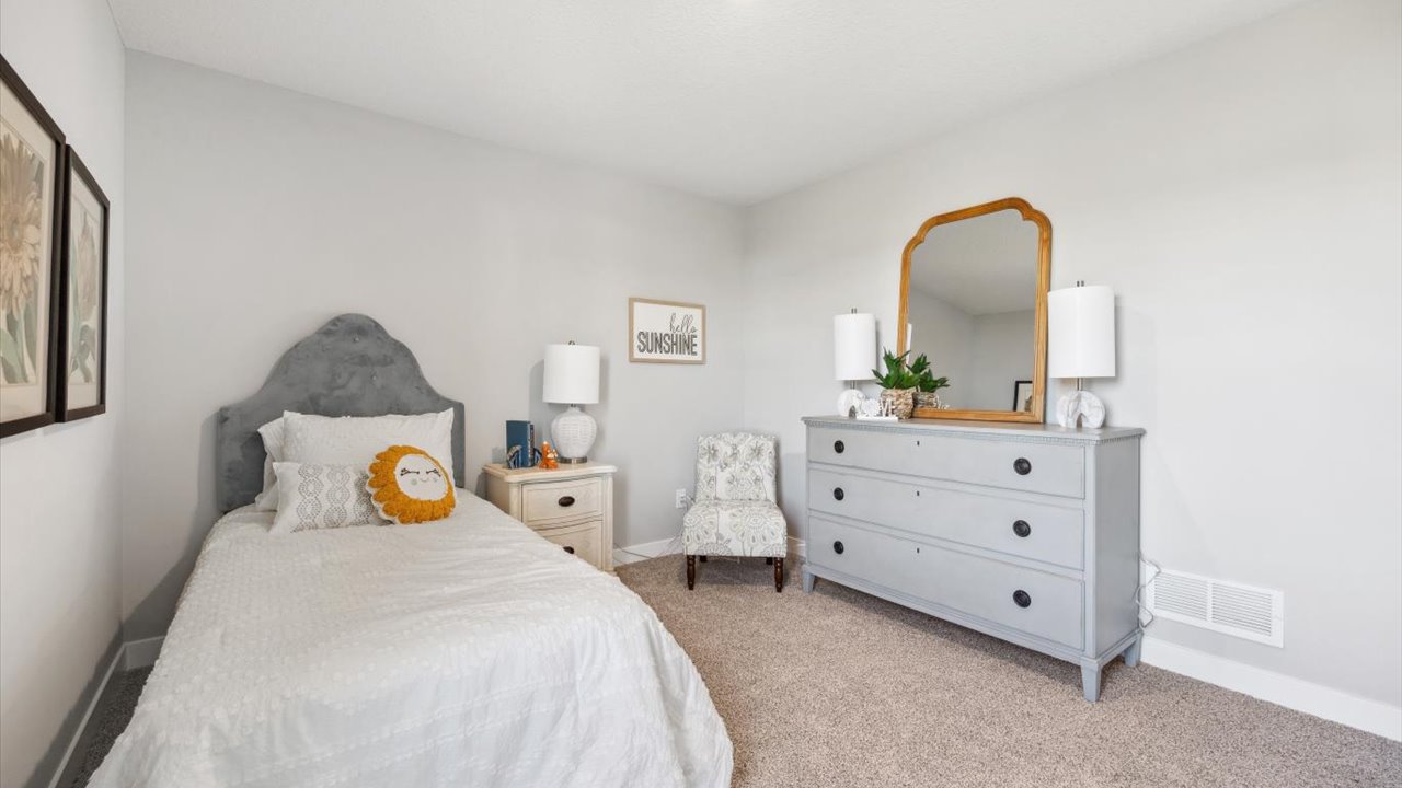 Carpeted secondary bedroom with standard closet.