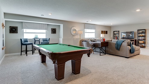 Finished lower level family room with tv area and a pool table.