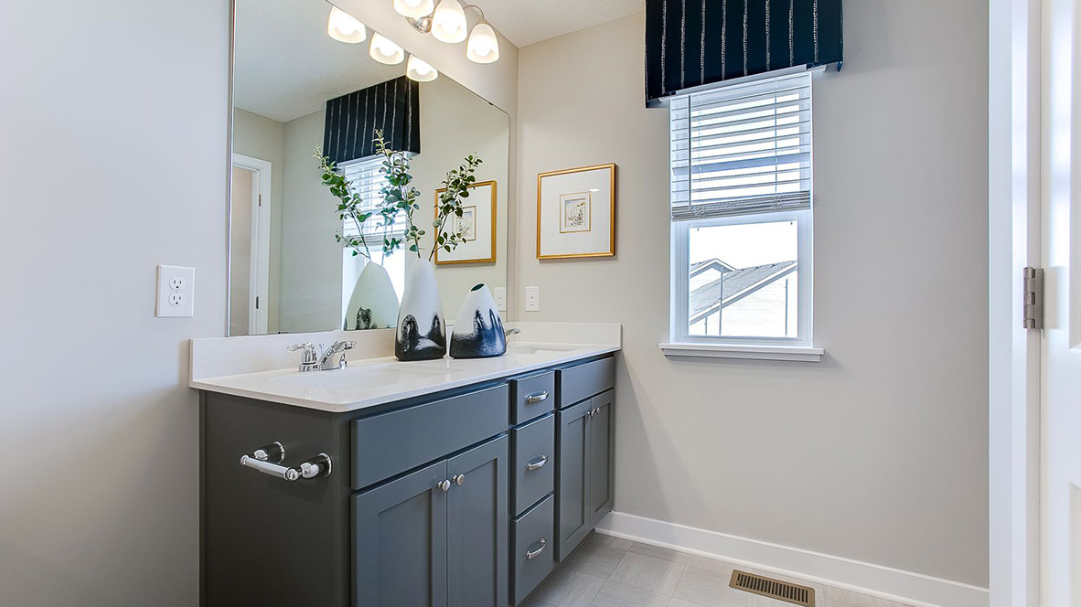 Private bathroom with harbor gray cabinets and quartz double vanity.