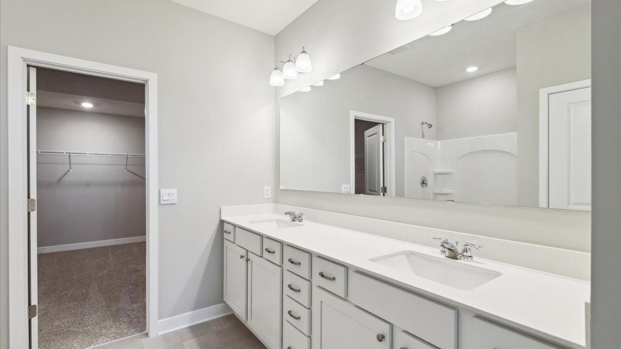 Bedroom suite's private bathroom with quartz double vanity and white cabinets.