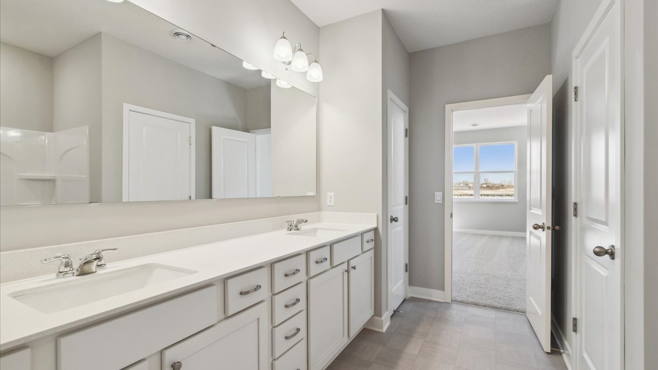 Bedroom suite's private bathroom leading into spacious walk-in closet.