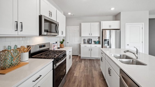 Tiled kitchen backsplash and cabinet hardware included.