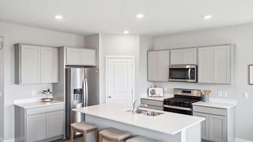 Spacious kitchen shown with gray cabinets.