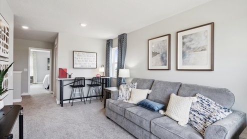 Upper level loft with couch, tv and desk.