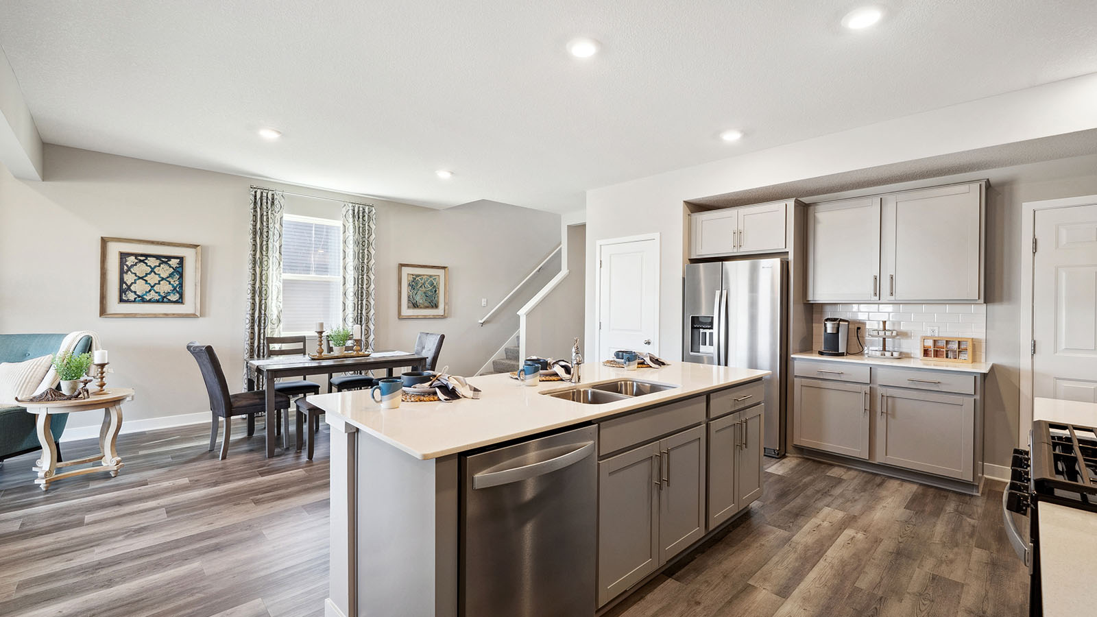 Kitchen island with gray cabinets and quartz countertops.