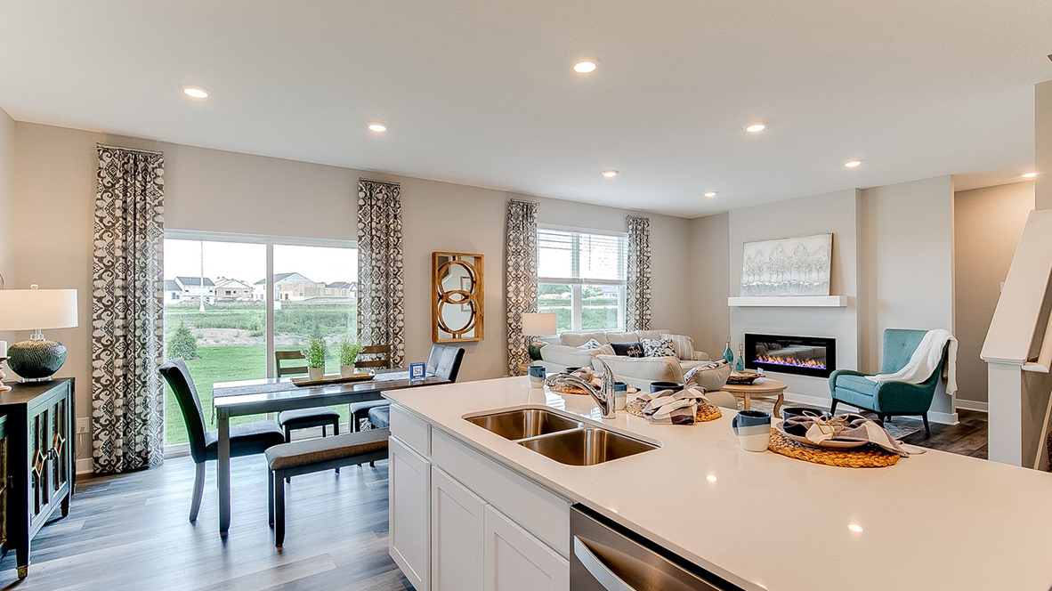 Angled view of kitchen with white cabinets and stainless steel appliances.