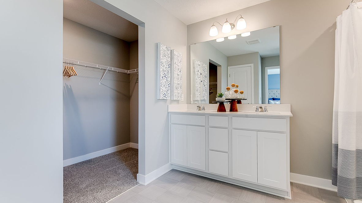 Bedroom suite's private bathroom leading into walk-in closet.
