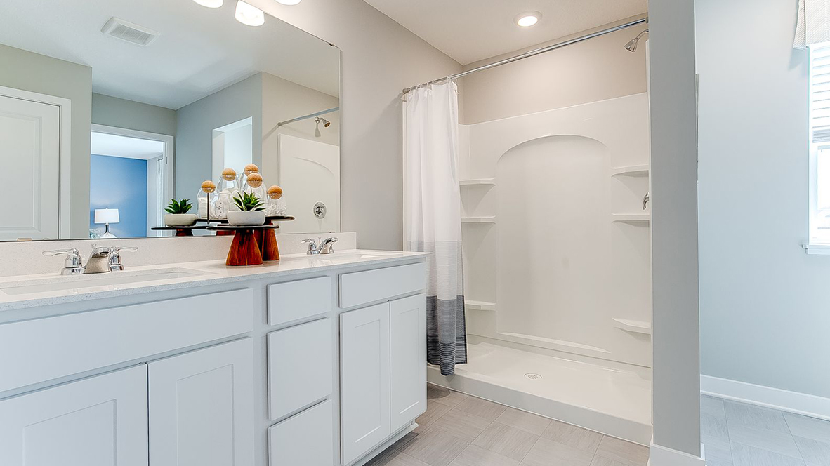 Private bathroom with white cabinets and quartz double vanity.