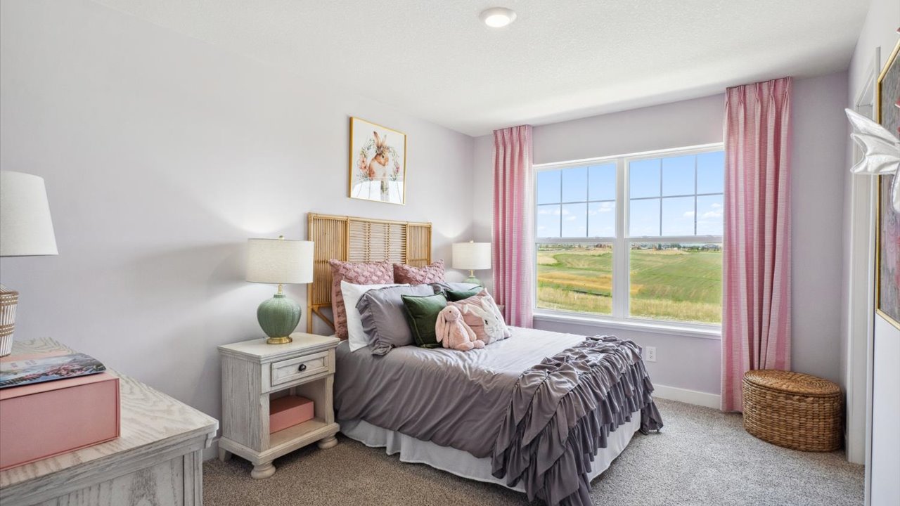 Carpeted secondary bedroom with walk-in closet.