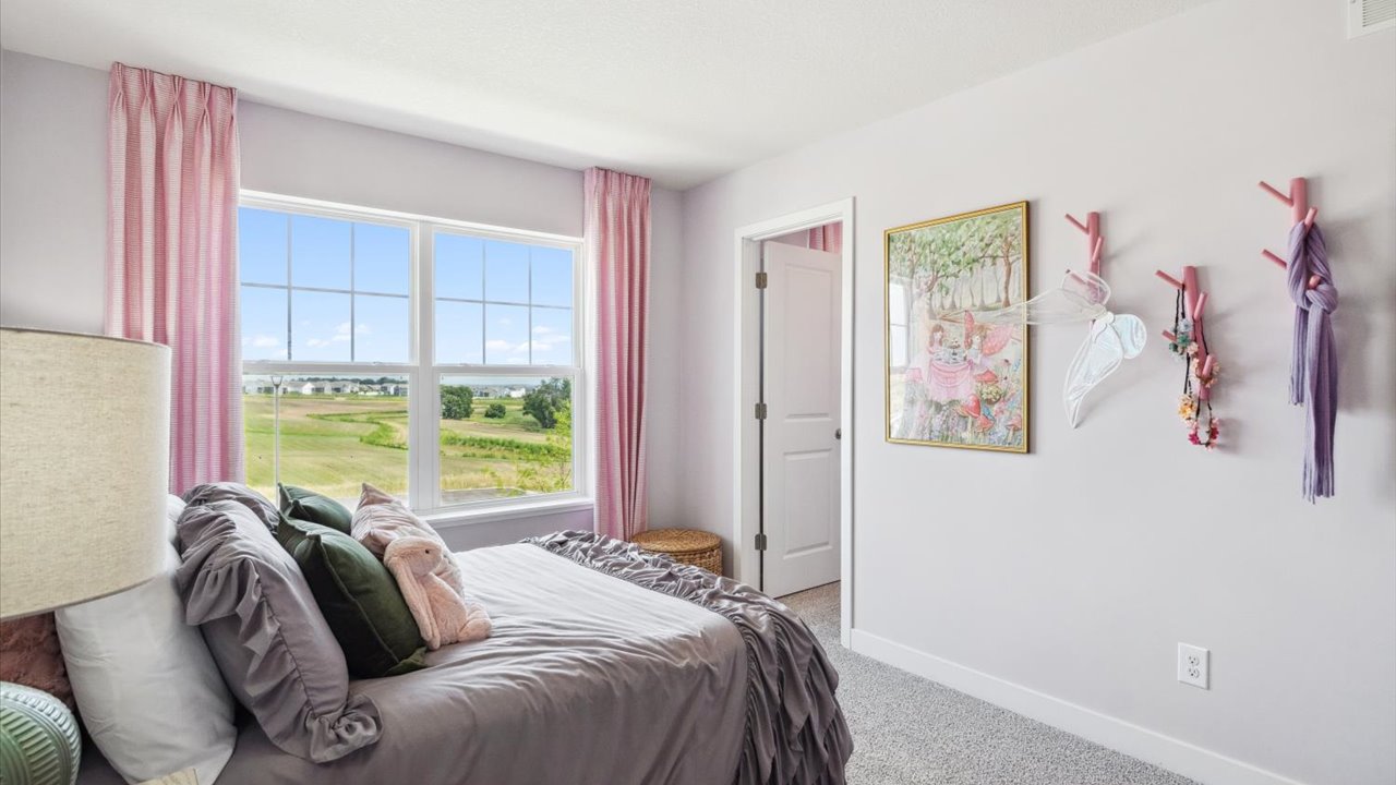 Carpeted secondary bedroom with walk-in closet.