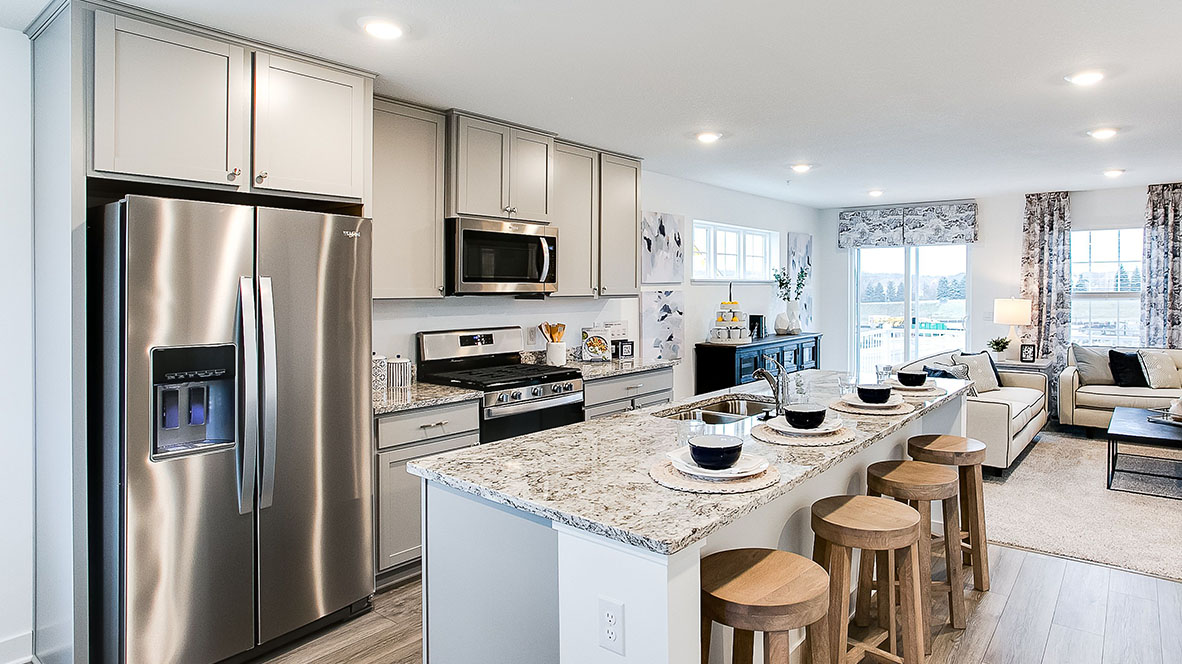 kitchen with light grey cabinetry, large island and stainless steel appliances