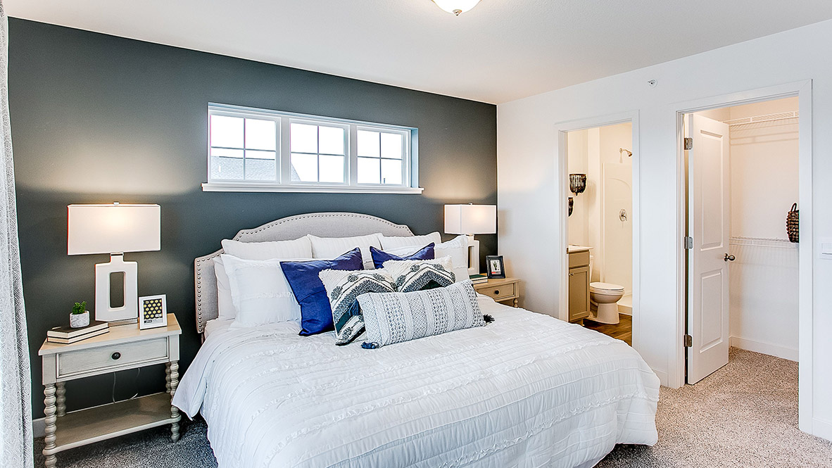 bedroom with beige carpet, white walls and a window
